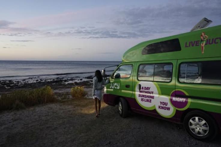 7 day road trip itinerary adelaide to melbourne 1 girl stands by jucy condo at sunset in adelaide