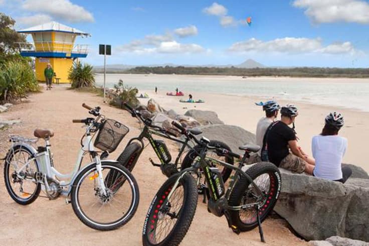 brisbane to noosa road trip itinerary 3 tourists visiting noosa on electric bikes with eco trek