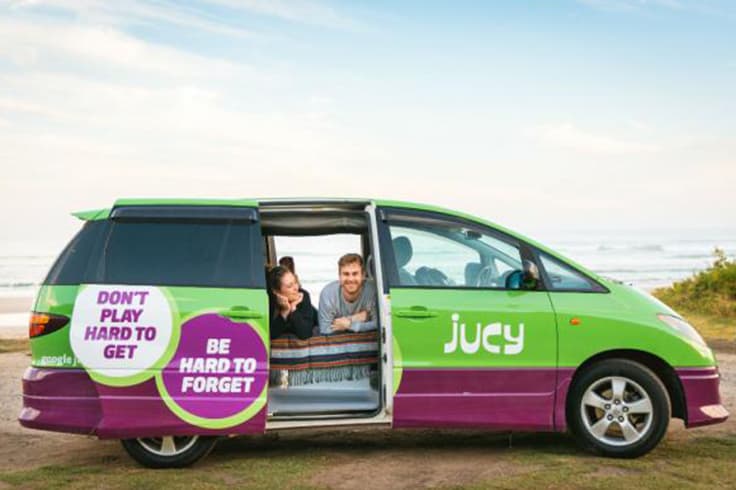 two people in a bed in the back of a jucy campervan two people in a bed in the back of a jucy campervan