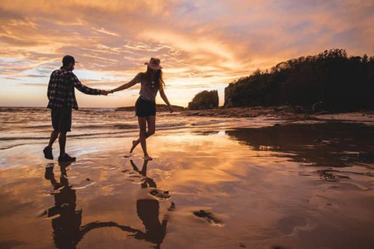 make the most of your working holiday australia 1 Couple walking along a beach at sunset