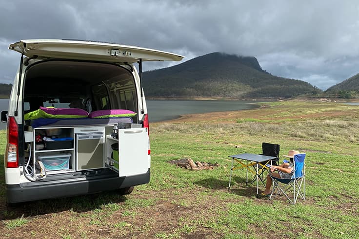 girl sitting at camp by Lake Moogerah & Mount Edwards