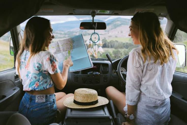 10 reasons you should road trip to splendour in the grass 2 2 girls looking at a map in a campervan