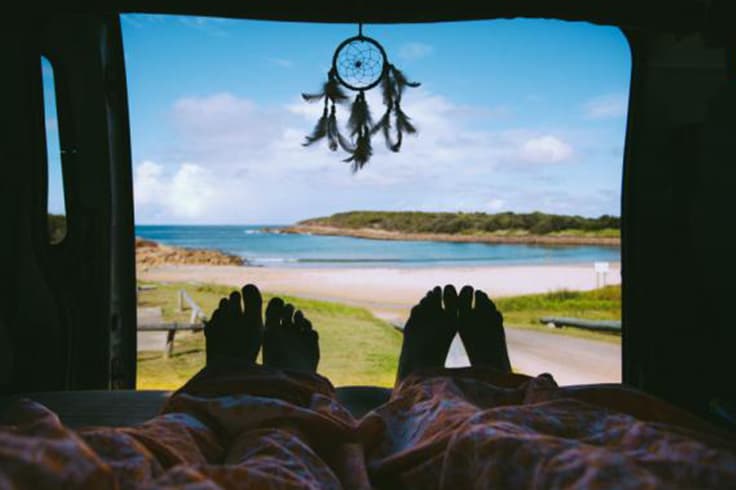 10 reasons you should road trip to splendour in the grass 3 2 people waking up to a beach view in a campervan