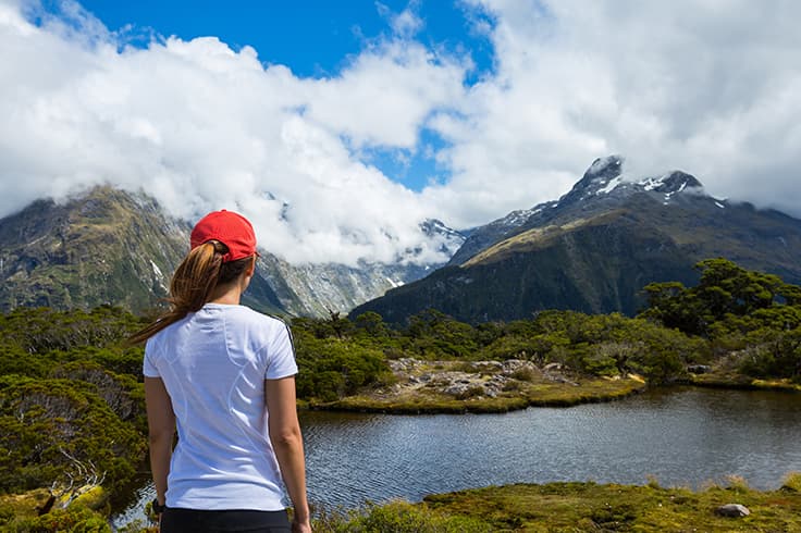 Girl looking out to a view of a lake and mountains Girl looking out to a view of a lake and mountains